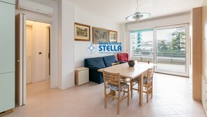 Un appartement moderne comprenant un coin repas, un canapé et une grande fenêtre.