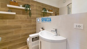 Un baño moderno con pared de madera, lavamanos blanco y espejo.