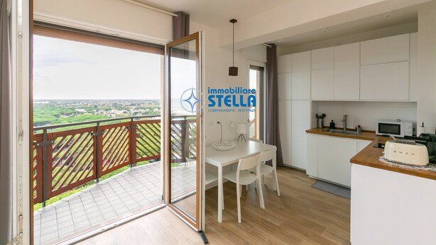 Un apartamento moderno con balcón, comedor y cocina.