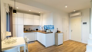Una cocina moderna con armarios blancos, una mesa de comedor y un microondas integrado.
