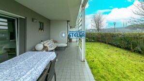 Un dormitorio con cama, sofá y ventana con vistas a un jardín.