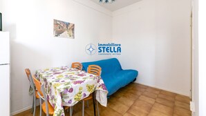 Ein Essbereich mit Tisch, Stühlen, einer Couch und einem Wandbild.
