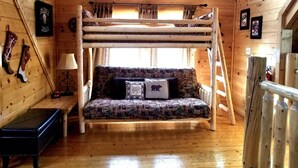 A bunk bed with a patterned mattress, a bedside table with a lamp, and a clock. - Amazing Grace - Two Bedroom Cabin (Sevierville)