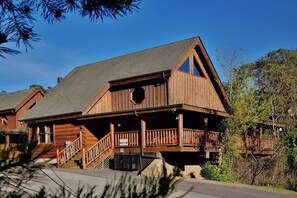 A wooden cabin with a porch, a staircase, and a clear sky. - Amazing Grace - Two Bedroom Cabin (Sevierville)