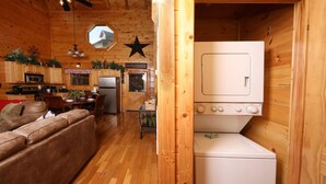 A compact wooden cabin with a kitchenette, a dining area, and a laundry room. - Amazing Grace - Two Bedroom Cabin (Sevierville)