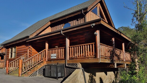 A wooden lodge with a balcony, a staircase, and a sign indicating it is a lodge. - Amazing Grace - Two Bedroom Cabin (Sevierville)