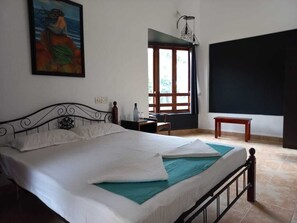 Un dormitorio con cama, un cuadro en la pared, una ventana y una puerta.