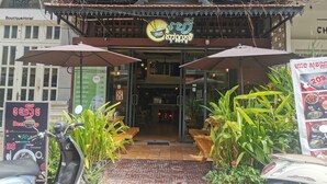 A restaurant with a signboard, outdoor seating, and a scooter parked in front. - Sovanphum Riverside Hotel (Phnom Penh)