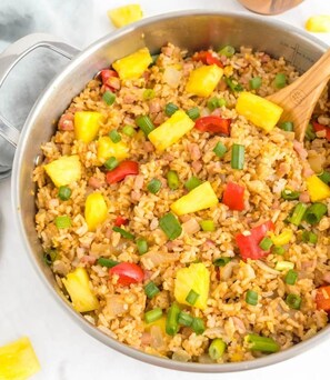 A close-up of a meal, likely fried rice, with visible ingredients like pineapple, green onions, and red bell peppers. - Sovanphum Riverside Hotel (Phnom Penh)