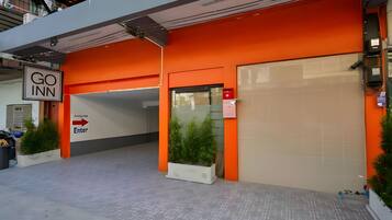 A Go Inn hotel entrance with a clear 'Enter' sign, a parking garage entrance, and a gated driveway.