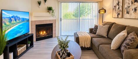 A living room with a fireplace, a television, a sofa, and a coffee table.