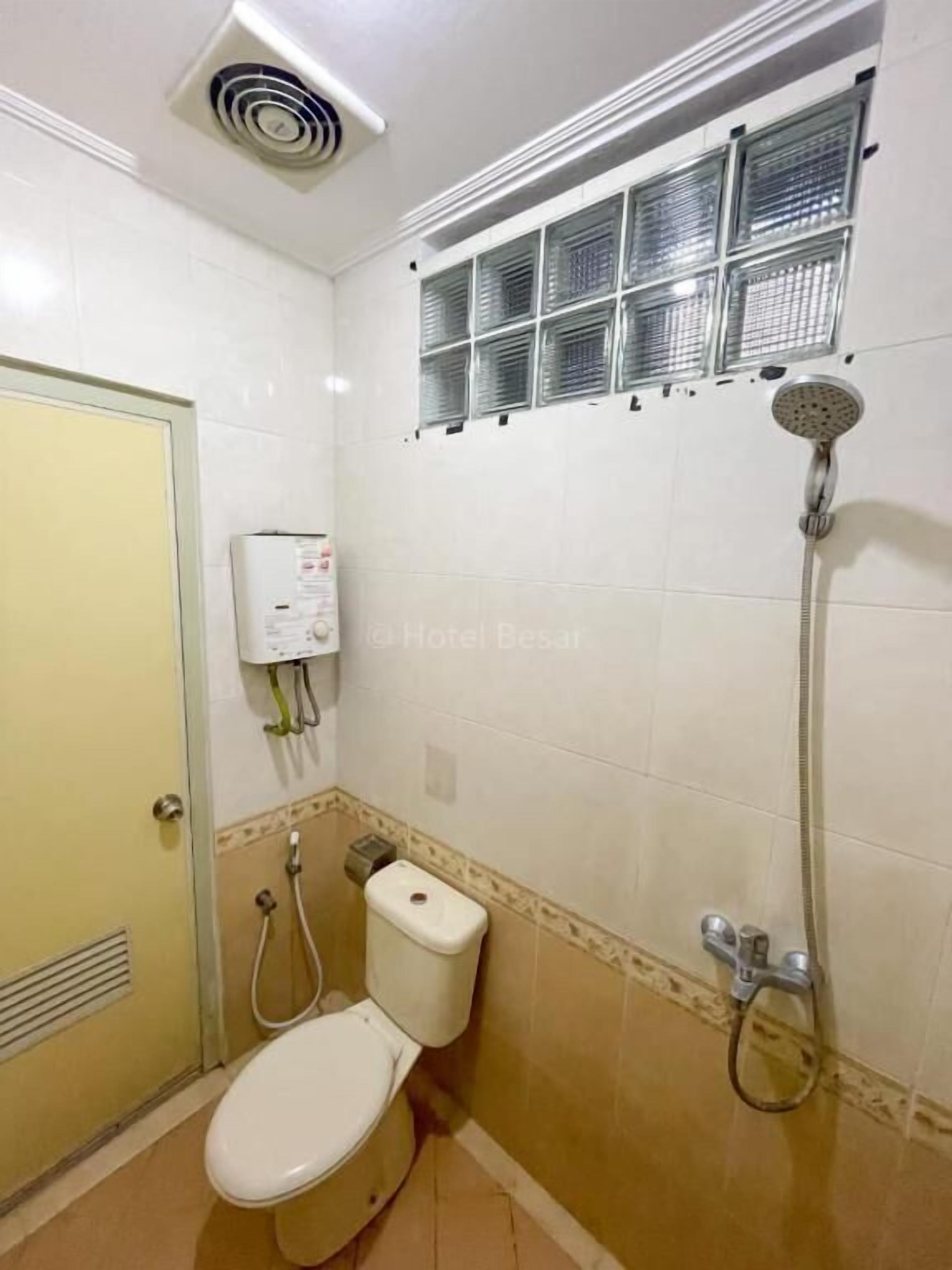 Une salle de bain équipée de toilettes, d’une douche et d’un système de ventilation.