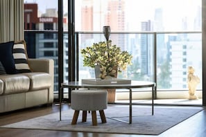 A modern living room with a sofa, a small round table, and a potted plant. - Peppers Retreat Atop The Broadbeach Skyline (Gold Coast)