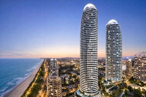 Two tall, cylindrical buildings with a modern design, situated near a coastline. - Peppers Retreat Atop The Broadbeach Skyline (Gold Coast)