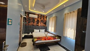 A modern bedroom with a bed, bedside table, and a ceiling fan. - BALAJI HOTEL AND RESTAURANT (Uluberiya)