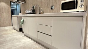A modern kitchen with a built-in microwave, a sink, and a stainless steel faucet. - Belin Stay Myeongdong & Jongno (Seoul)