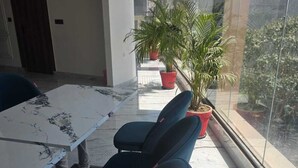 A conference room with a marble table, black chairs, and potted plants. - HOTEL R R TRIPATHI (Faizabad)