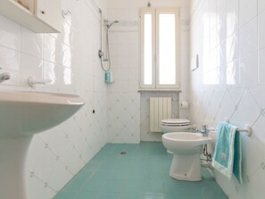 A bathroom with a sink, toilet, and shower. - One bedroom apartment with sea view terrace (Lacona)