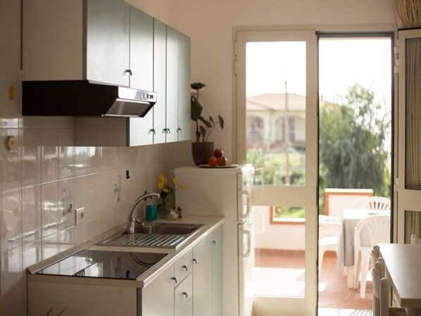 A kitchen with a sink, cabinets, and a view of the outside. - One bedroom apartment with sea view terrace (Lacona)