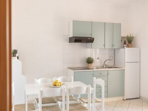 A compact kitchen with white cabinetry, a built-in stove, and a sink. - One bedroom apartment with sea view terrace (Lacona)