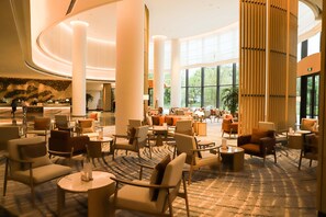 A spacious lobby with high ceilings, large windows, and a variety of seating arrangements. - Mauve Glamor Chengdu (Chengdu)