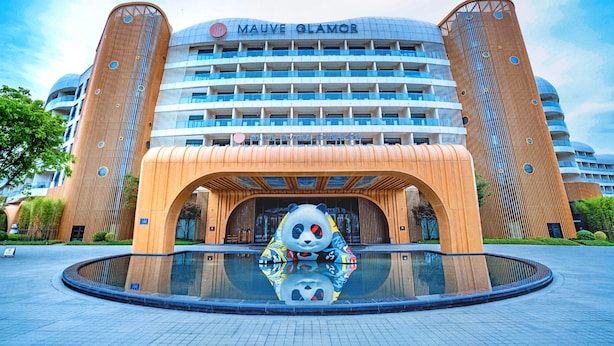 A hotel with a distinctive panda sculpture in front, a large glass facade, and a modern architectural design. - Mauve Glamor Chengdu (Chengdu)