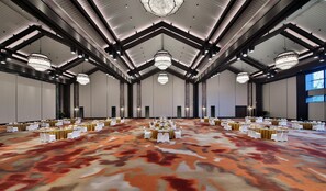 A large conference room with high ceilings, chandeliers, and rows of tables set for a formal event. - Mauve Glamor Chengdu (Chengdu)