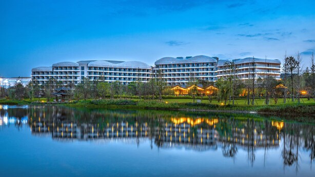 A modern hotel with multiple dome-shaped buildings, a reflective lake, and a well-maintained garden. - Mauve Glamor Chengdu (Chengdu)