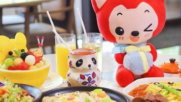 A table with various dishes, a stuffed animal, and a drink.