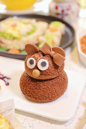 A dessert with a bow on top, placed on a white plate. - Mauve Glamor Chengdu (Chengdu)