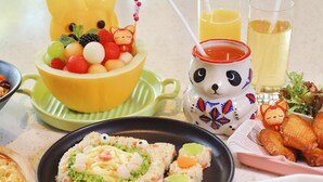 A table with various dishes, including a bear-shaped dessert, a plate of rice with vegetables, and a bowl of soup. - Mauve Glamor Chengdu (Chengdu)