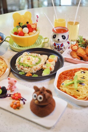 A table with various dishes, including a bear-shaped dessert, a plate of rice with vegetables, and a bowl of soup. - Mauve Glamor Chengdu (Chengdu)