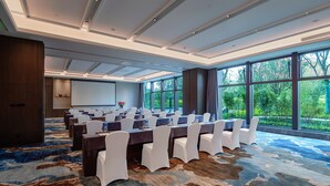 A conference room with a large table, white chairs, and a carpeted floor. - Mauve Glamor Chengdu (Chengdu)