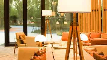 A modern lobby with a seating area, a lamp, and a view of the outdoors.