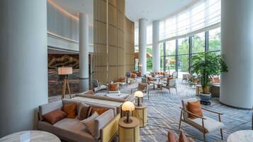 A spacious lobby with seating areas, a large plant, and a modern design.