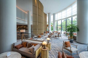 A spacious lobby with seating areas, a large plant, and a modern design. - Mauve Glamor Chengdu (Chengdu)