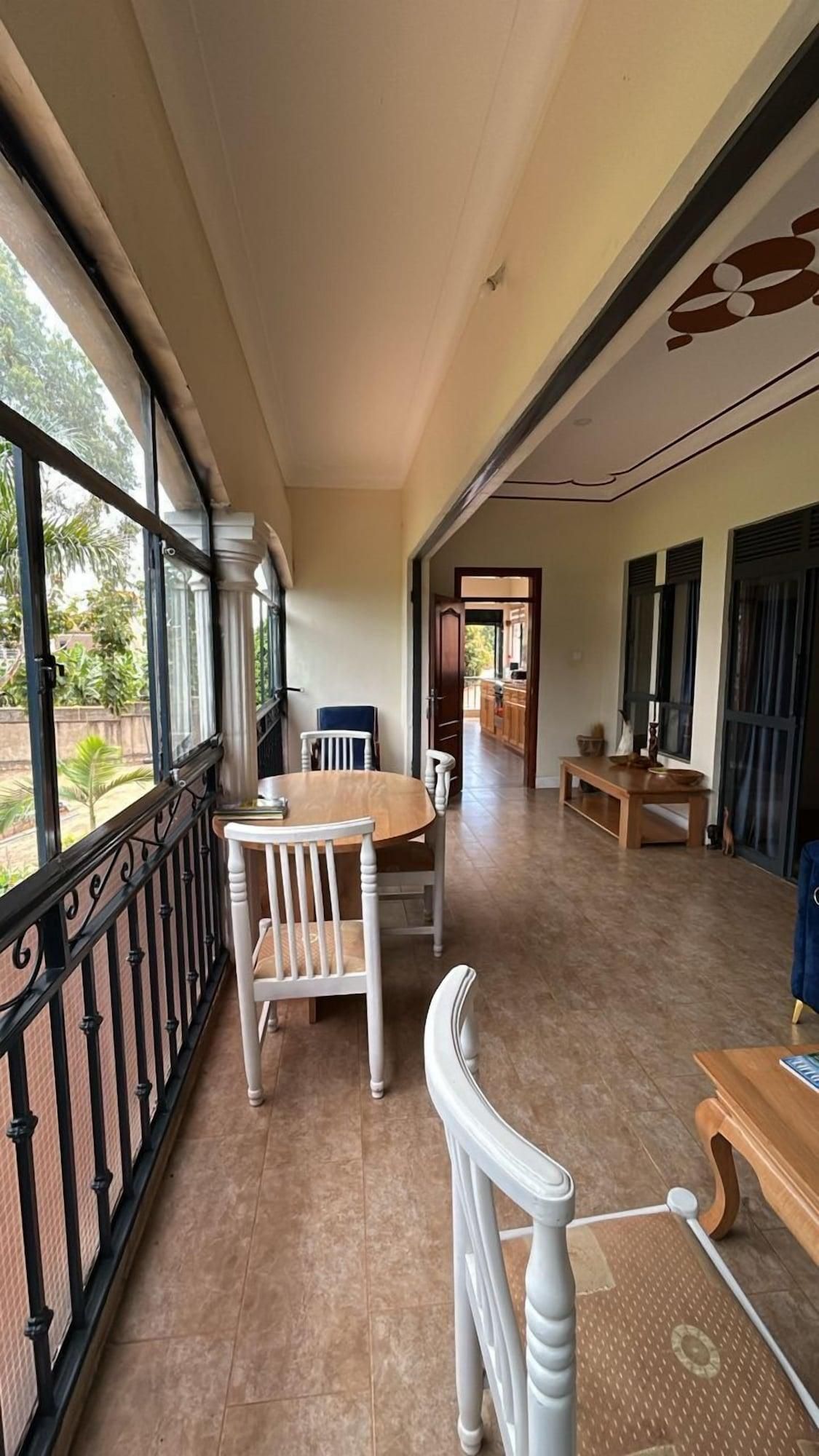 Un pasillo con comedor que incluye una mesa y sillas, vistas amplias a través de grandes ventanales y una zona de cocina al fondo.