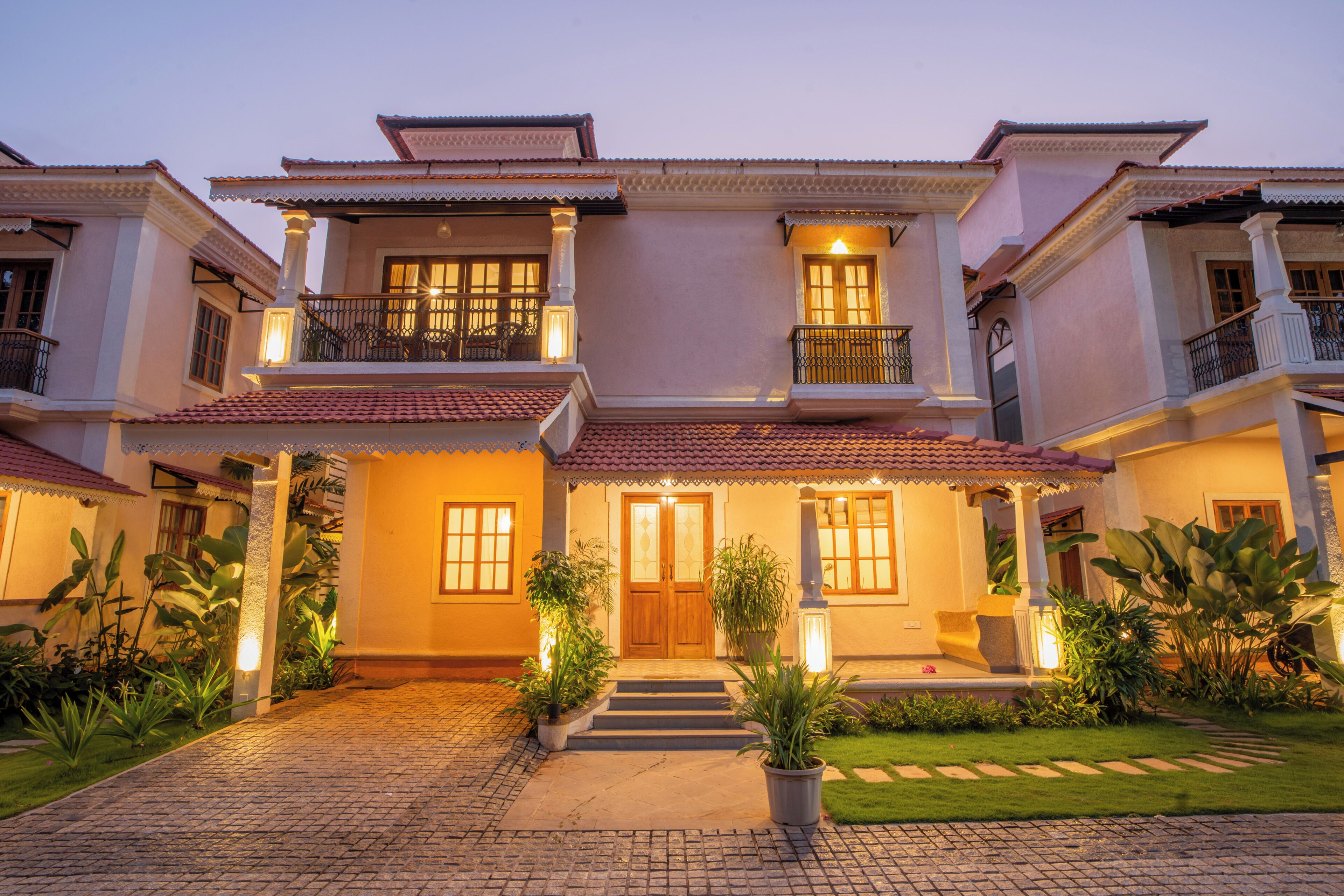 A two-story house with a tiled roof, a front porch, and a well-maintained garden.