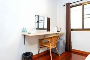 A compact room with a desk, chair, and a small refrigerator. - The Hidden Giant Swing (Bangkok)