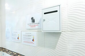 A wall with multiple signs, including one instructing to return keys to a box and another about cleaning or signing for room cleaning. - The Hidden Giant Swing (Bangkok)