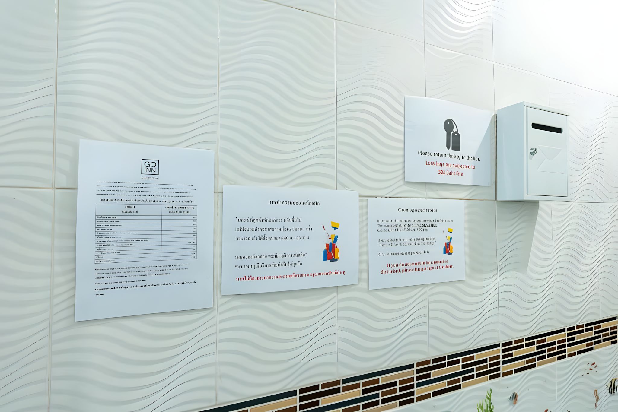 A wall with multiple informational signs, including a key return instruction and a map.