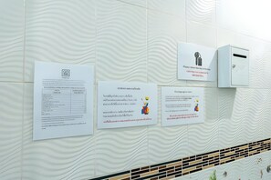Eine Wand mit mehreren Hinweisschildern, darunter eine Wegbeschreibung und eine Karte.
