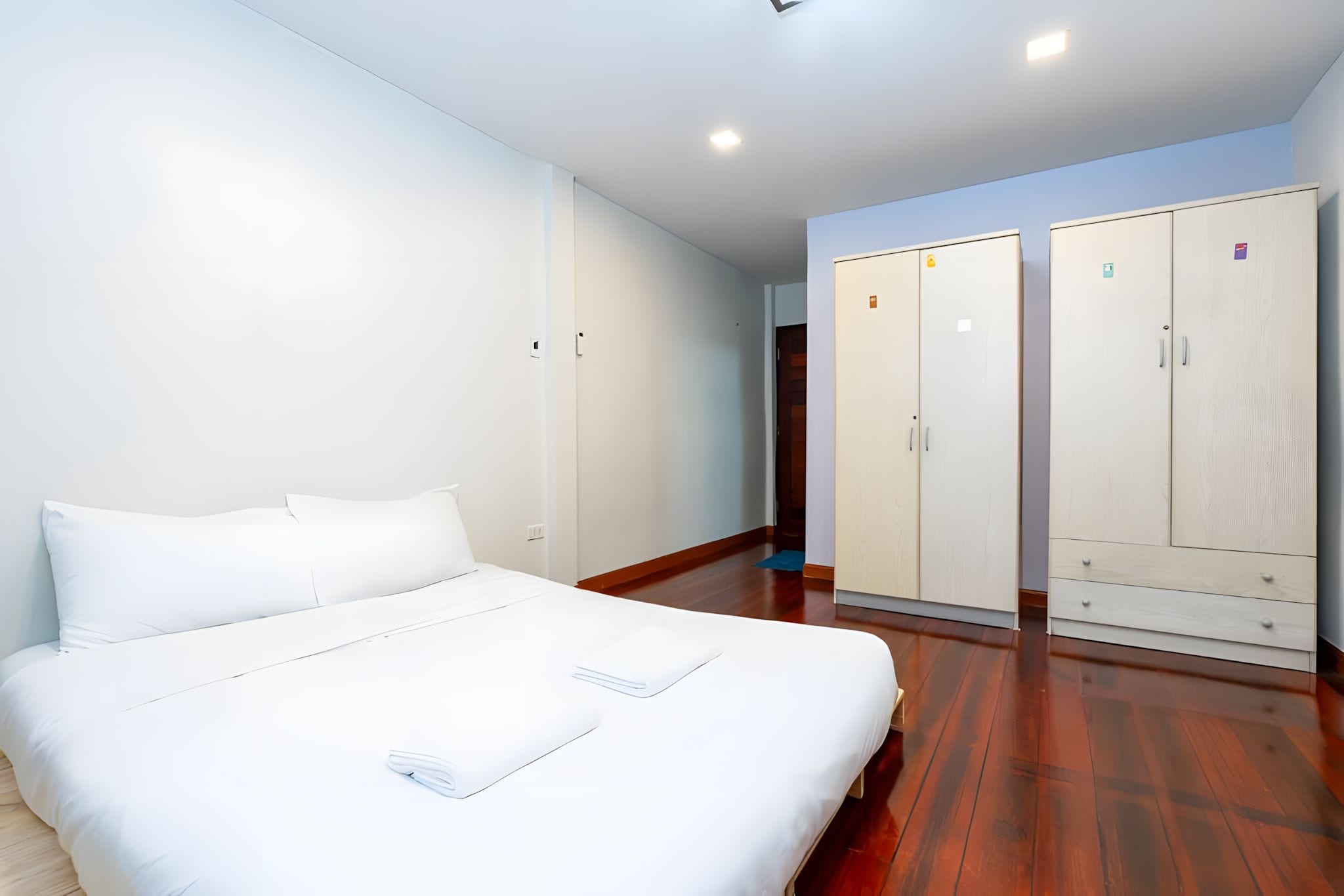 A hotel room with a bed, a wardrobe, and a bathroom.