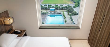 King Room Pool View | Minibar, in-room safe, desk, blackout drapes