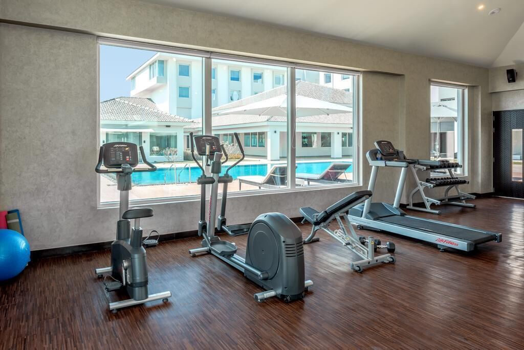A gym with cardio machines, a rowing machine, and a bench press.