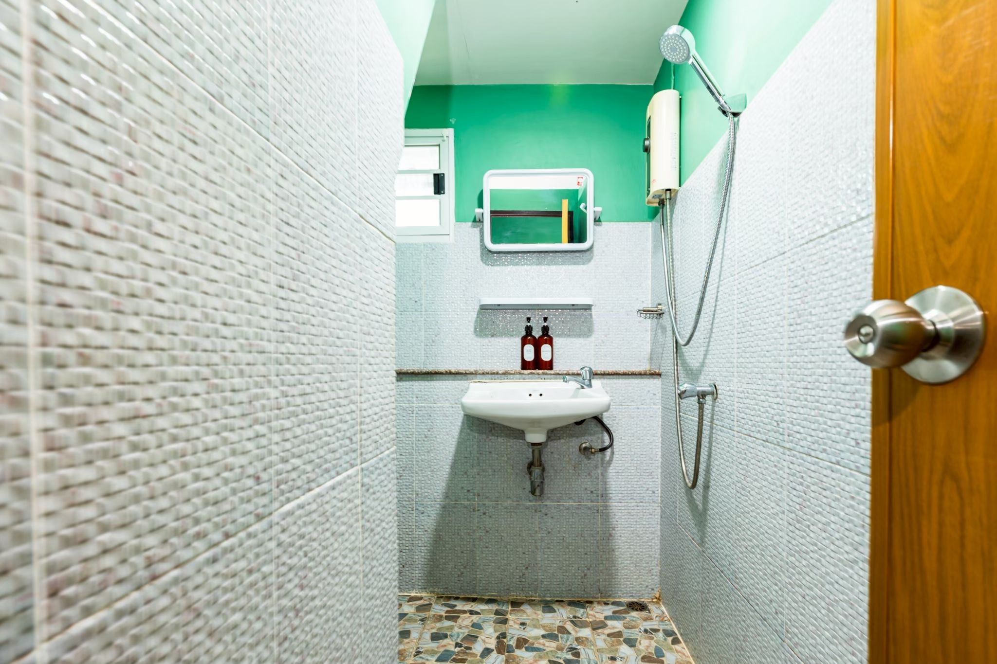 A bathroom with a white sink, a mirror, and a shower.
