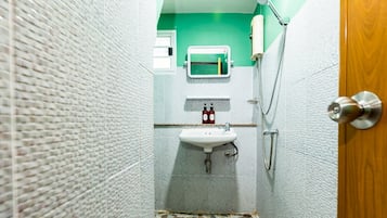 A bathroom with a white sink, a mirror, and a shower.
