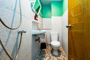 Un baño con inodoro, lavamanos y ducha.
