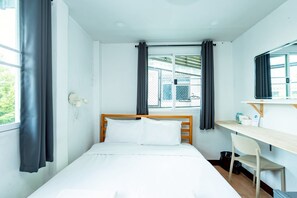 A small, clean room with a single bed, a desk, and a chair. - GO INN The Giant Swing (Bangkok)