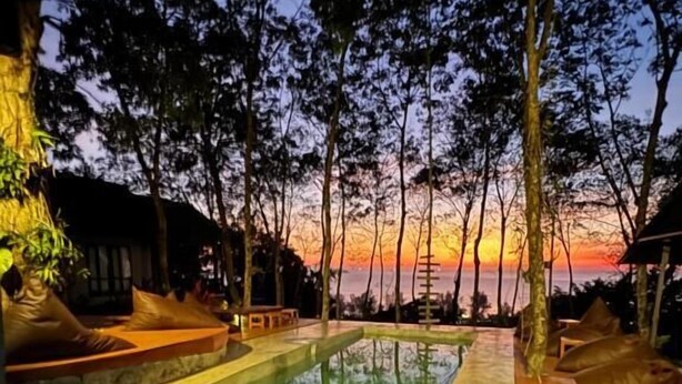 A swimming pool with lounge chairs and a view of the sunset. - Drifter's Anchor (Ko Chang)